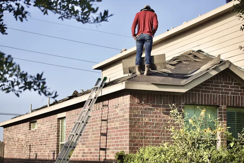 Professional roofer working on a residential roof in Mission Woods